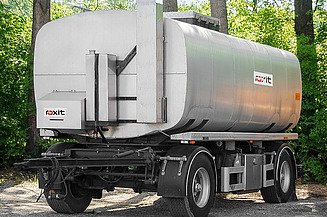 Tankanhänger für den Transport von Bitumenemulsionen auf einer befestigten Fläche abgestellt, mit zylindrischem Lagertank und technischer Ausrüstung.