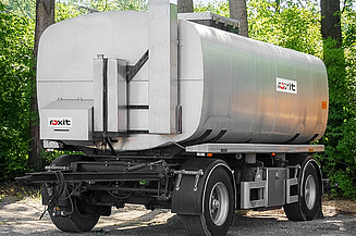Tank trailer for the transport of bitumen emulsions parked on a paved surface, with cylindrical storage tank and technical equipment.