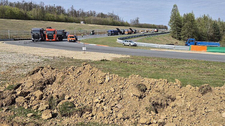 Curved section of the Masaryk Ring in Brno with several lorries and road construction machines in use