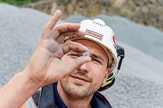 Mitarbeiter im Baustoffbereich prüft Materialqualität auf einer Baustelle – Karriere in nachhaltigen Baustoffen und moderner Bauindustrie