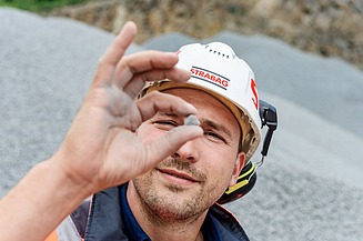 Employee in the building materials sector checks material quality on a construction site - Career in sustainable building materials and modern construction industry